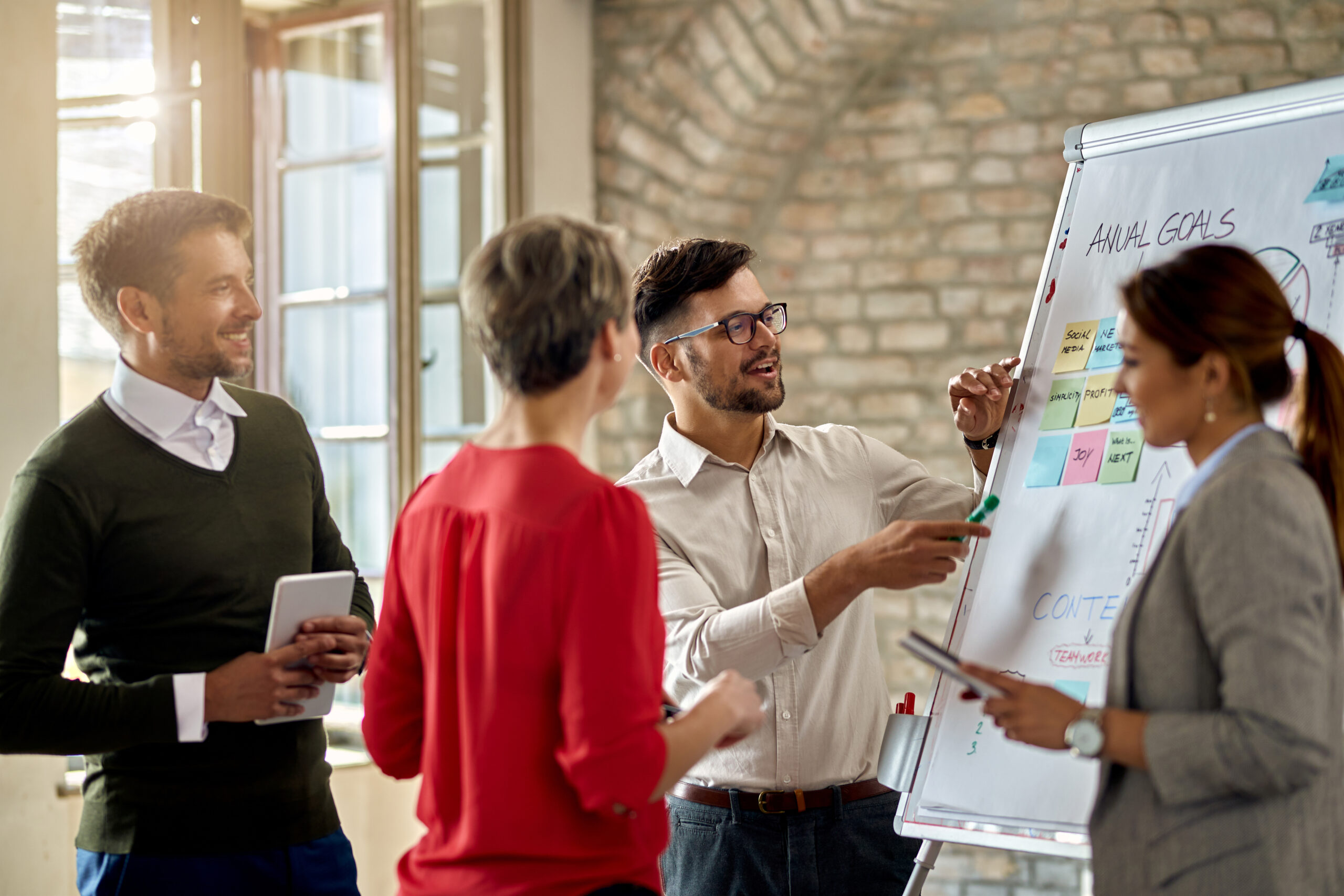 Partner marketing team discusses full funnel marketing strategy using a whiteboard in a modern office